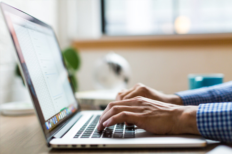 A distributor at their desk, working with a laptop.